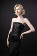 © Mountains Hunter - Expressive young blonde under a bob in the studio. In a black corset and dress.