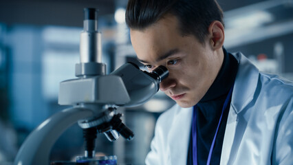Aufkleber - Medical Research and Development Laboratory: Young Caucasian Male Scientist Looking at a Biological Sample in a Petri Dish Under a Microscope in an Advanced Biotechnology Lab