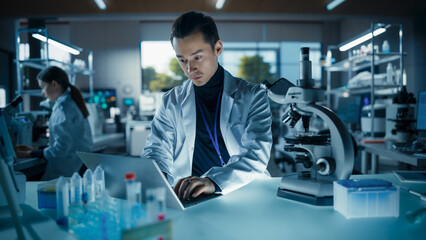 Aufkleber - Portrait of a Young Graduate Student Working in a Laboratory, Using Laptop, Writing Down Research Data on a Computer. Multiethnic Biotechnology Specialist Using Modern Tools