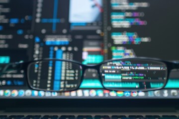 Leinwandbilder - Coding session in a modern workspace with ambient lighting during the evening hours showing lines of programming code on a widescreen monitor