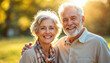 © abu - Smiling senior couple outdoors, framed by sunlight in a warm, cheerful park setting.