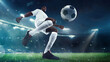 © master1305 - Low angle view on focused man, soccer player in white uniform, dribbling ball with precision against evening sky and fans tribune on background. Concept of sport, tournament, competition, game event