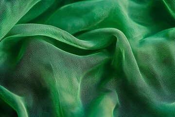 Close-up of green mesh fabric, with waves and folds, against a vibrant green background. 