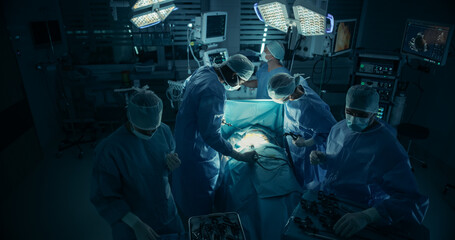Poster - Black Male and a Caucasian Female Surgeons Performing a Hard Surgical Procedure in a Dark Operating Room Under Surgical Light. Diverse Hospital Team at Work