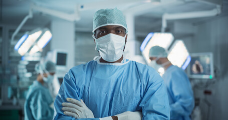 Poster - Portrait of a Black African American Male Doctor or Surgeon Wearing a Protective Face Mask and Disposable Surgical Cap. Medical Person Calmly Looking at Camera in Operating Room