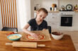 © Katrin_Primak - little girl making pizza dough on wooden tabletop in kitchen