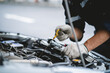 © KANGWANS - A mechanic is working on a car engine, checking the oil level and adding more if necessary. Concept of responsibility and attention to detail
