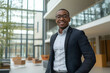 © Krisz G - Portrait of a successful African American businessman looking at camera and smiling inside modern office building