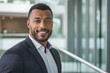 © Krisz G - Portrait of a successful African American businessman looking at camera and smiling inside modern office building