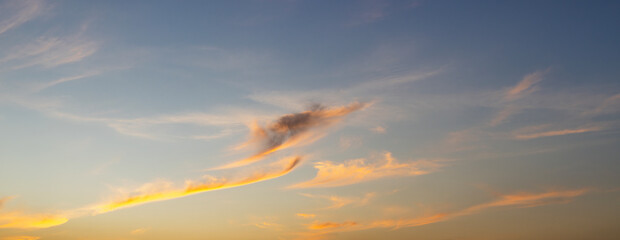 Wall Mural - sunset sky background in the evening with clouds and colorful orange sunlight on twilight sky.