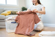© Pormezz - Laundry household work concept, asian woman working on fresh clean clothes.