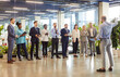 © Studio Romantic - Multicultural group of businessmen standing in a row in a hotel lobby. Employees listen to the event organizer. Concept of distribution of responsibilities for the company, corporate training