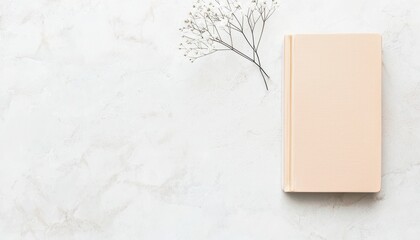 Poster - Minimalist Flat Lay Composition Featuring a Single Book and Delicate Flower on a Light Background