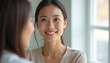 © stockphoto02 - A young woman smiles warmly  engaging in a pleasant conversation with a friend.