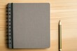 © Andrei - clean notebook mockup with blank cover placed on minimalist wooden desk with pencil nearby