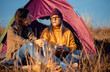 © Zoran Zeremski - Two women camping at top of the hill sitting in front of the tent resting after hiking.