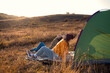 © Zoran Zeremski - Two women camping at top of the hill sitting in front of the tent resting after hiking.