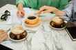 © RooM The Agency - Three young women discussing work processes, signing documents and drinking coffee at a cafe