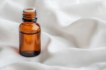 Poster - Small amber essential oil bottle resting on soft white fabric