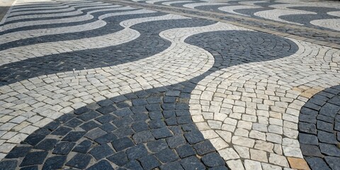 Leinwandbilder - A close-up view of a cobblestone walkway, featuring a pattern of black and white stones arranged in a unique and intricate wave-like design.