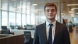 © liliyabatyrova - A poised young investment banker stands in a sleek office space, showcasing professionalism and ambition. Sunlight floods through large windows, illuminating the modern decor