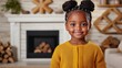 © saokaew - A cheerful girl with braided hair smiles in a cozy room, wearing a warm yellow sweater, with a fireplace and decorative elements in the background.
