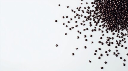 Poster - Black beans scattered on a white surface showcasing their glossy texture and shape in a top-down view suitable for culinary backgrounds