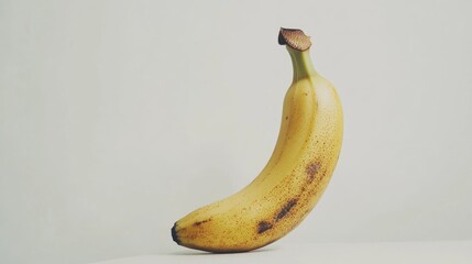Aufkleber - Fresh ripe banana with slight blemishes isolated on a light background perfect for nutrition or healthy eating concepts.