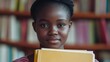 © VirtualVista - Young African teenage schoolgirl holding textbooks while studying at home with a focused expression in a cozy library setting.