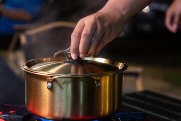 Wall Mural - A brass pot is placed on a picnic stove for boiling soup.