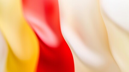 Poster - Flowing satin fabric creates an elegant, abstract background, with smooth waves of red, yellow, and white colors blending softly together, evoking a sense of luxury and romance