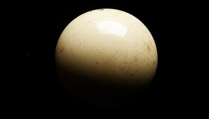 Aufkleber - A smooth, spherical object illuminated against a dark background.