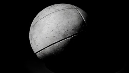 Aufkleber - A textured, spherical object illuminated against a dark background, emphasizing its form.