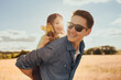 © kieferpix - Happy father child giving his daughter a ride on his back in the park.smiling walking and playing outdoors in a meadow