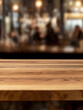 © MCGORIE - Sleek, empty wooden counter in a well-lit restaurant interior. The blurred background of moving people adds a sense of dynamic energy and depth.