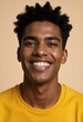 © Metehan - Happy young African American gen z guy winking isolated on beige background. Playful ethnic teen student, cool curly generation z teenager smiling with white perfect teeth, close up portrait.