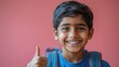 © Vii - A young boy carrying a backpack gives a thumbs up, conveying optimism and positivity