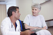 © peopleimages.com - Checkup, tablet and senior woman with doctor, hospital and explaining of diagnosis and retirement. Clinic, medical professional and healthcare for person with disability, wheelchair and talking