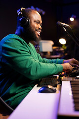 Leinwandbilder - Audio engineer with headset mixing and mastering his recorded files, operating on a professional soundboard in home studio. Artist producer composing new tracks with sound effects.