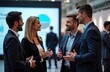 © Maryna - Four businesspeople engage in animated discussion at trade show. Business attire indicates pro setting. Diverse group converses, likely focused on business opportunities ideas. Large presentation