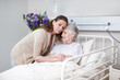 © peopleimages.com - Elderly woman, daughter and hug in hospital for medical exam, consultation or doctor appointment. Family, senior care and support in clinic for visit, healthcare services or bonding as cancer patient