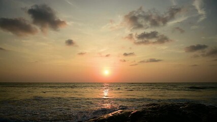 Wall Mural - timelapse of dramatic sunset with orange sky in a cloudy day at the ocean.