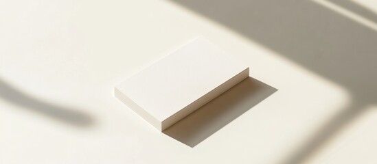 Wall Mural - Blank white rectangle card mockup on a beige surface with shadows.