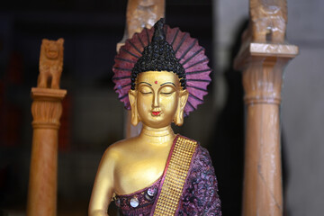 Wall Mural - A close-up of the face of a statue of Buddha is sold in a souvenirs shop in India