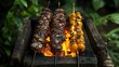 © Roman - Two skewers of grilled meat and vegetables sizzling over open flames, set in a lush green outdoor setting for a rustic barbecue experience