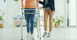 © peopleimages.com - Legs, physiotherapist and walker for patient, support or help for recovery, steps or guide at hospital. Doctor, frame and person with disability for rehabilitation, balance or feet at wellness clinic
