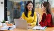 © David - Shot of two businessasianwomen working together on digital tablet. Creative female executives meeting in an office using tablet pc and smiling.