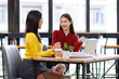 © David - Shot of two businessasianwomen working together on digital tablet. Creative female executives meeting in an office using tablet pc and smiling.