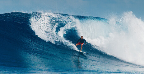 Wall Mural - Pro surfer rides big wave in the Maldives