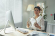© crizzystudio - Attractive Asian businesswoman wearing headphones working from home office Have online video calls with customers and co-workers. sing songs play music Live happily on your PC. Success concept.